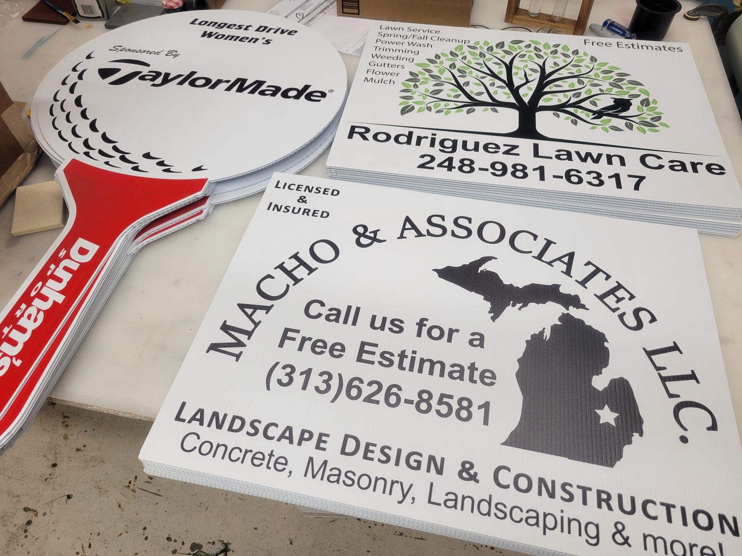 Yard Signs for Rodriguez Lawn Care and Macho & Associates LLC, and a stack of hole sponsor signs for a golf course charity event, contour cut into the shape of a golf ball on a tee. (designed in house at InkBird Print Studio!)