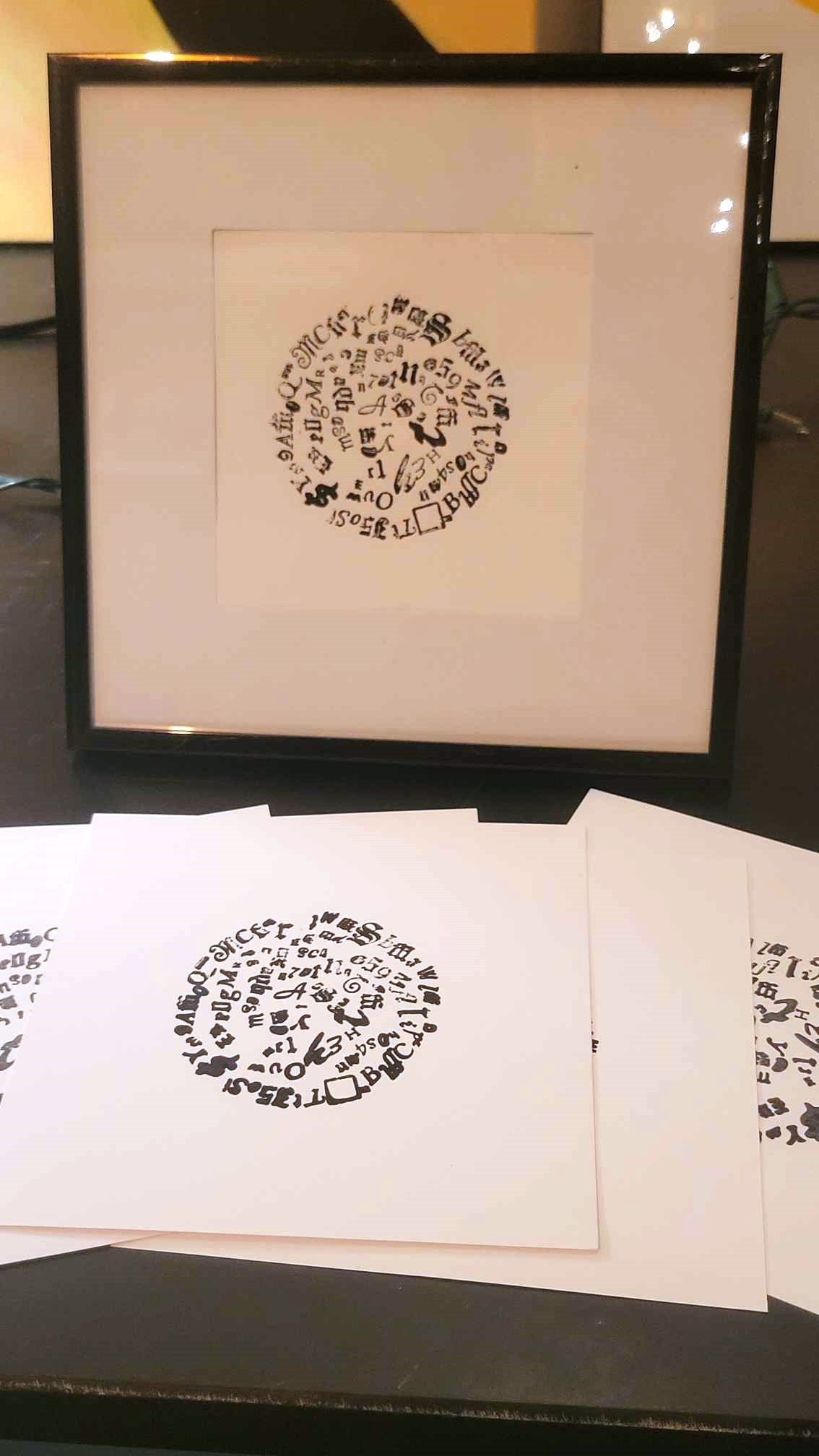 Letterpress Circle wall art print by Claire Davis—black ink on white heavyweight paper, features unique typographic circle design.
