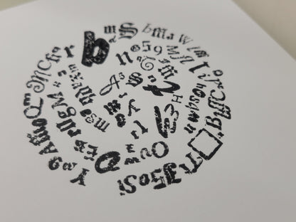Letterpress print features a black and white circle of mixed fonts, symbols, and numbers on white paper; LIMITED RUN by Claire Davis.