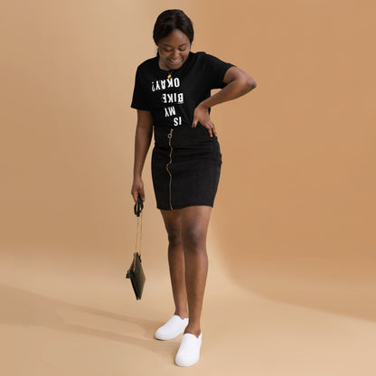 Woman wears InkBird Print Studio’s “Is My Bike Okay?” cotton T-shirt, white print on black, paired with zip-front mini skirt and small bag.