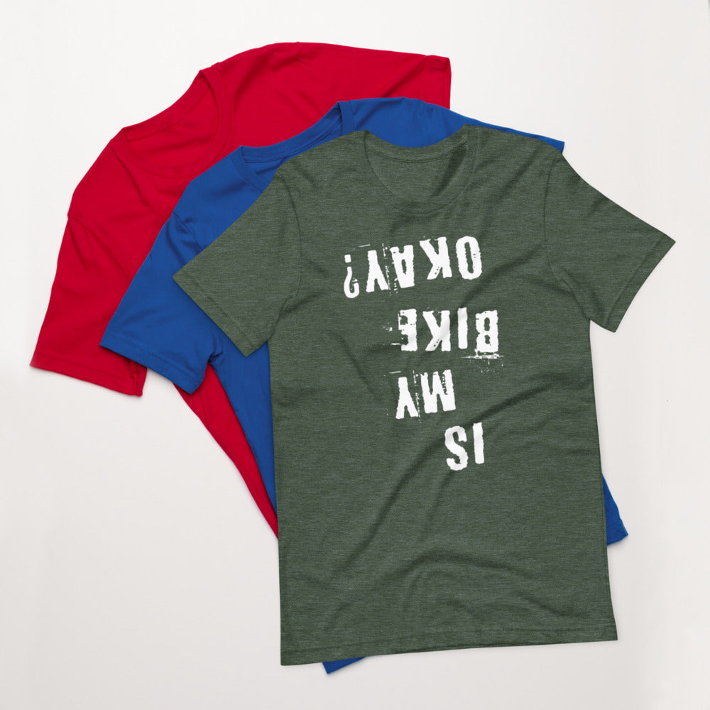 Green cotton Is My Bike Okay? mountain biking t-shirt by InkBird Print Studio, size medium, atop blue and red shirts.