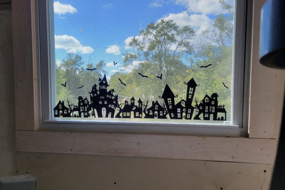 Spooky Static Cling set by InkBird Print Studio. Black ink on clear static material shown on a window with a sunny exterior shown behind it. Showcases the opaque nature of the ink.