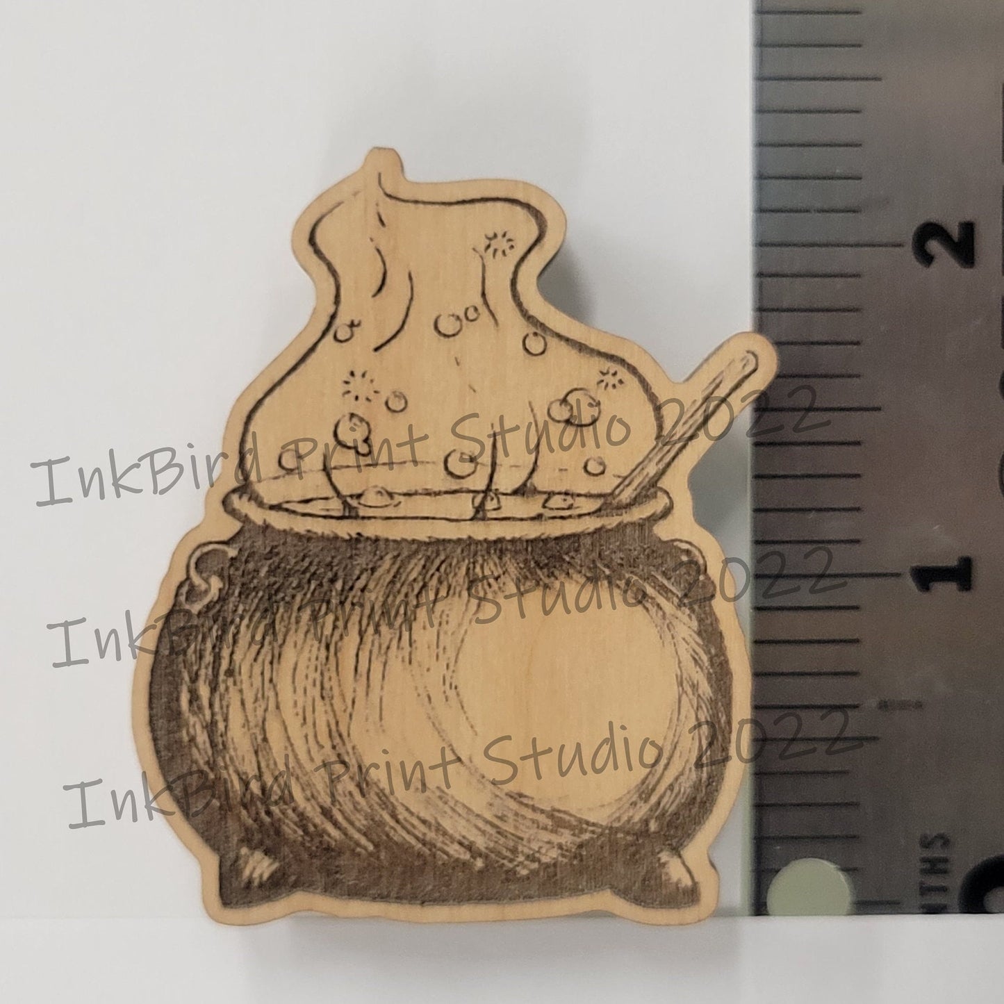 2-inch neodymium wood magnet with detailed, sketch-style cauldron and spoon engraving by InkBird Print Studio LLC.